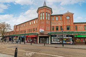 a large red brick building on a city street at Alexandra House by Guestz in Stockport
