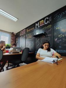 a woman sitting at a table in a classroom at MEC Office Hostel in Niterói
