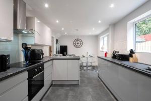 a large kitchen with white cabinets and a window at Brumby 3-Bed House by Brookland Stays Serviced Accommodation with WiFi in Brumby +10 photos