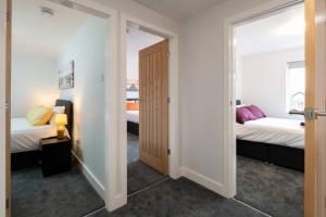 a room with two beds and a door to a bedroom at Brumby 3-Bed House by Brookland Stays Serviced Accommodation with WiFi in Brumby