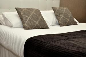 a bed with two pillows and a white comforter at Hôtel du Mont Blanc in Paris