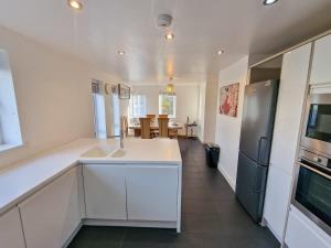 a kitchen with a sink and a refrigerator at 4 Bed Home in Altrincham by City SuperHost in Timperley