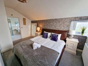 a bedroom with a large bed with purple pillows at 4 Bed Home in Altrincham by City SuperHost in Timperley