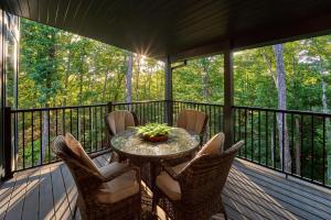 a patio with a table and chairs on a deck at Alta Maya in Gatlinburg