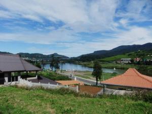 Blick auf einen Fluss mit Bergen im Hintergrund in der Unterkunft Kildare Cottage in Nuwara Eliya
