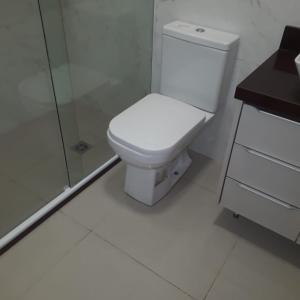 a white bathroom with a toilet and a shower at Comfort and Style White Queen II in Cuiabá