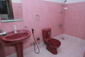 ein rosafarbenes Bad mit einem WC und einem Waschbecken in der Unterkunft Kildare Cottage in Nuwara Eliya