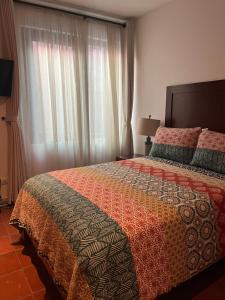 a bedroom with a large bed and a window at Cousy Condo in the historic center of San Miguel de Allende, incredible view, pool, BBQ, 3 blocks from the main parish in San Miguel de Allende +60 photos