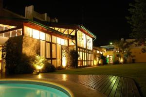 a house with a pool in front of it at night at Hotel Resort Posta De Juarez in Firmat