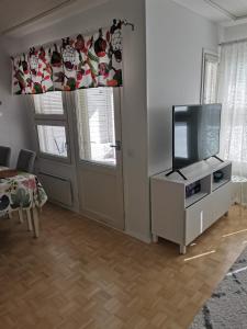 a living room with a flat screen tv and a door at Hirvikoto in Sotkamo