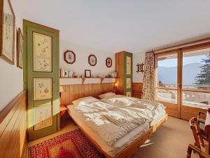 a bedroom with a bed and a large window at Gaiola 1er in Bagnes