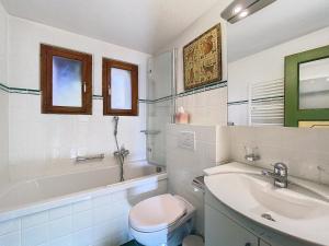a white bathroom with a toilet and a sink at Gaiola 1er in Bagnes +9 photos