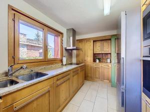 a kitchen with wooden cabinets and a sink and a window at Gaiola 1er in Bagnes