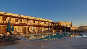 a hotel with a swimming pool in front of a building at Burcu Kaya Hotel in Ortahisar