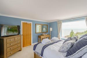 Un dormitorio con una cama y un televisor y una ventana. en Balcary Tower, en Castle Douglas