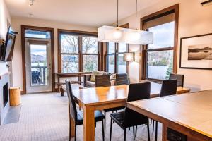 a dining room and living room with a table and chairs at Waterfront Suite & Lake Resort in Lac-Superieur
