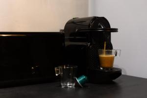 a coffee maker and a glass on a table at Cosy apartment - Near Paris - RER D in Villeneuve-Saint-Georges
