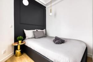 a black and white bedroom with a bed and a table at Cosy apartment - Near Paris - RER D in Villeneuve-Saint-Georges