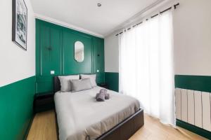 a bedroom with green walls and a bed with a teddy bear on it at Cosy apartment - Near Paris - RER D in Villeneuve-Saint-Georges +23 photos