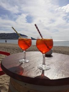 two drinks sitting on a table on the beach at Los Angeles in Roses