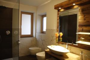a bathroom with a sink and a toilet and a shower at Hotel Enzian in Villa Ottone +28 photos