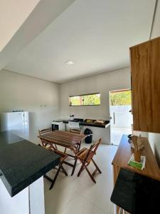 eine Küche mit Tisch und Stühlen in einem Zimmer in der Unterkunft Casa Guaiú - BA in Santa Cruz Cabrália