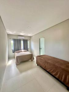 ein großes Schlafzimmer mit einem Bett und einem Fenster in der Unterkunft Casa Guaiú - BA in Santa Cruz Cabrália