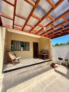 eine Terrasse mit einem Holzdach und einem Stuhl darauf in der Unterkunft Casa Guaiú - BA in Santa Cruz Cabrália + 15 Fotos