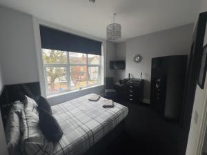 a bedroom with a bed and a large window at The Prince Alfred Rooms in Liverpool