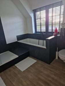 une salle de bain avec baignoire et toilettes dans l'établissement Huswell - The Cozy Relax Home, à Beernem
