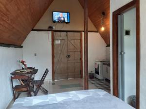 a bedroom with a bed and a television on a wall at Chalé Floresta in Paraty
