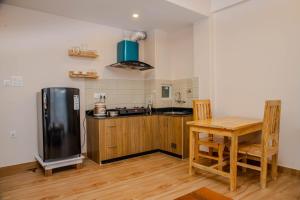 una cucina con frigorifero nero e tavolo in legno di Montana Inn a Pokhara