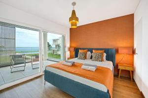 een slaapkamer met een groot bed en een balkon bij Mar a Vista - Condominium with Pool, Gym and Sea Views in Nazaré