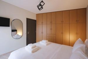 a bedroom with a white bed and a mirror at Tyto Alba Habitat in Athens