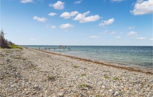 a rocky beach with a pier in the water at Holiday Home Ørnevej Sjællands Odde Denm in Yderby +39 photos