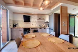 una gran mesa de madera en una cocina con sillas en Lona Spa, en Chambon-sur-Lac 7 fotos más