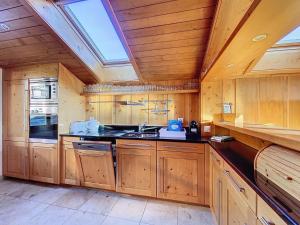 a large kitchen with wooden cabinets and a skylight at Gaiola 2ème in Bagnes