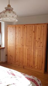a bedroom with wooden cabinets and a large bed at Appartamento Bellavista in Cavalese