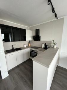 a kitchen with white cabinets and a counter top at Ferienwohnung Fördedeck in Kiel