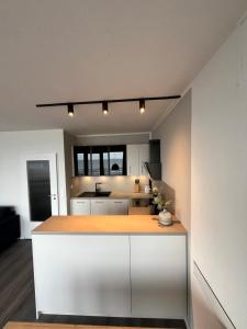 a kitchen with white cabinets and a wooden counter top at Ferienwohnung Fördedeck in Kiel