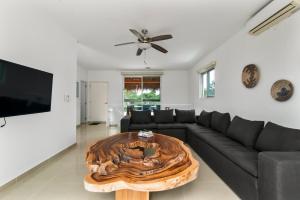 a living room with a black couch and a wooden coffee table at Casa Lula 5-BR Getaway in Riviera Maya in Playa del Carmen