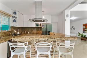 a kitchen with white chairs and a marble counter top at Casa Lula 5-BR Getaway in Riviera Maya in Playa del Carmen