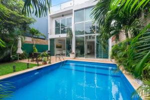 a swimming pool in front of a house at Casa Lula 5-BR Getaway in Riviera Maya in Playa del Carmen