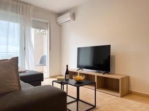 Una sala de estar con un sofá y un televisor de pantalla plana. en TAYP San Marcos 107, en Talayuela