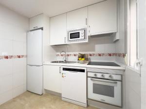 Una cocina blanca con fregadero y microondas. en TAYP San Marcos 107, en Talayuela 19 fotos más