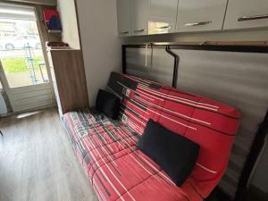 a red bed with two pillows in a room at Studio au pied des pistes avec terrasse, parking et animaux acceptés! - FR-1-692-102 in La Chapelle-dʼAbondance