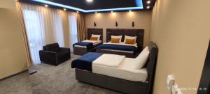 ein Schlafzimmer mit 2 Betten und einem Stuhl darin in der Unterkunft HOTEL LOBBY in Bihać