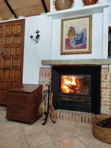 a living room with a fireplace with a fire at Casa Rural del Guadalora in Hornachuelos