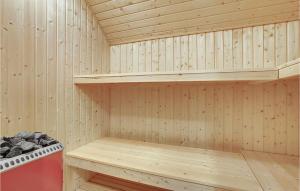 a sauna with wooden walls and wooden shelves at Nice Home In Hvide Sande With Sauna in Bjerregård +19 photos