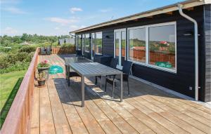 eine Holzterrasse mit einem Picknicktisch auf einem Haus in der Unterkunft Holiday Home Knebel 3 in Knebel